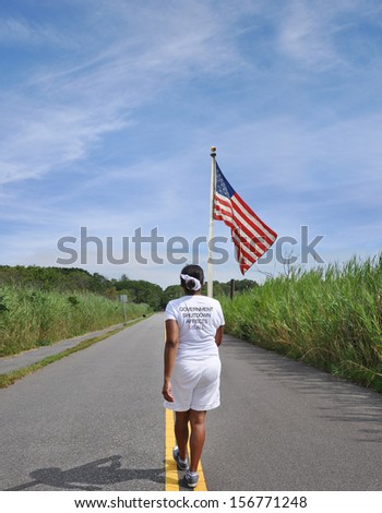 Government Shutdown on Tee Shirt of Woman Walking with American Flag