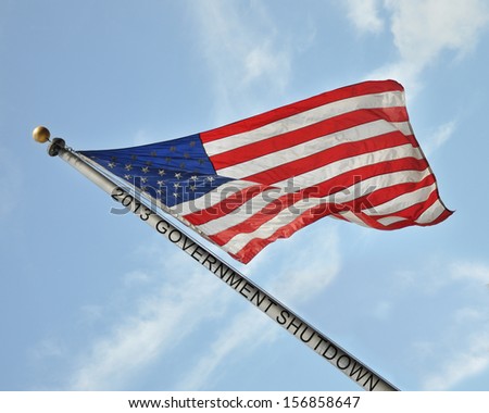 American Flag Leaning Blowing in Wind with 2013 Government Shutdown on Flag Pole Blue Sky