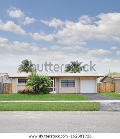 Suburban Ranch Style Home Palm Trees Landscaped House Front Blue Sky Clouds Residential Neighborhood USA