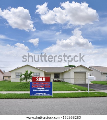 Sold Real Estate Sign Front Yard Lawn Suburban Ranch Style Home Residential Neighborhood USA Blue Sky Clouds