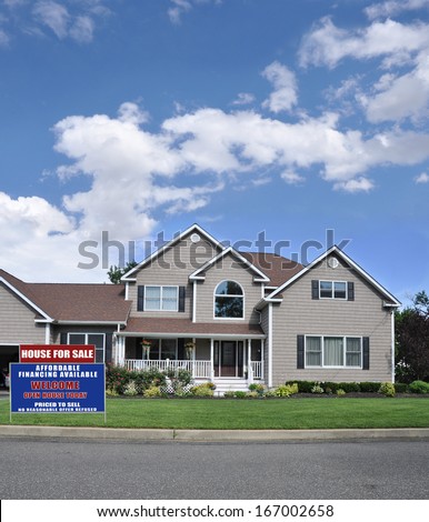 Real Estate For Sale Sign Front yard lawn Suburban McMansion style Home with flowers beautifully landscaped Residential Neighborhood USA Blue Sky Clouds