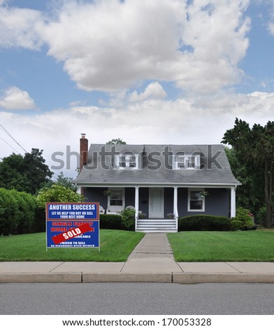Sold Real Estate For Sale Sign Front yard Lawn Suburban Cape Cod Style Home in Residential Neighborhood Blue Sky Clouds USA