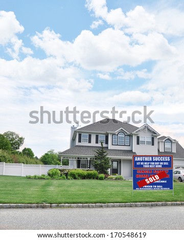 Real Estate Sold (Another Success Let Us Help You Buy Sell Your Next Home) Sign Suburban McMansion Style Home Blue Sky Clouds Residential USA Neighborhood
