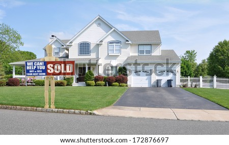 Sold Real Estate Sign Adult Mannequin Suburban Mcmansion house front sunny blue sky clouds USA residential neighborhood
