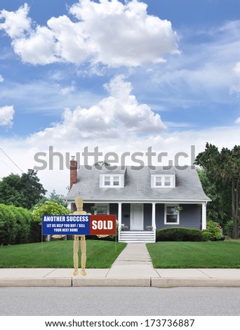 Sold Real Estate Sign held by Adult Wood Mannequin front your curb of suburban Cape Cod style home blue sky clouds residential neighborhood USA