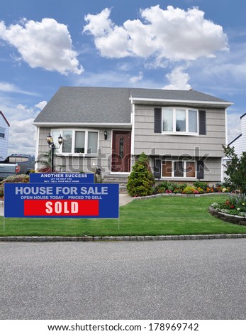 Sold Real Estate Sign (Another success let us help you buy sell your next home)Suburban Cape Code style home with Dormer residential neighborhood USA blue Sky clouds