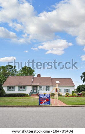 Mannequin Wearing Red Tie standing next to Real Estate Sold (Another success let us help you buy sell your next home) sign Suburban Ranch style home brick walkway residential neighborhood USA