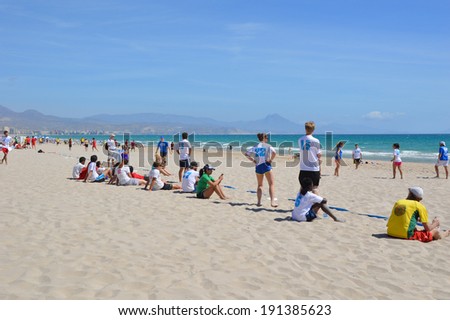 ALICANTE, SPAIN - APR 27: Barcelona\'s Brava Frisbee team member sitting on sideline in yellow watching Ultimate Frisbee Tournament game hosted on San Juan beach Apr 26-27 in Alicante Apr 27, 2014.