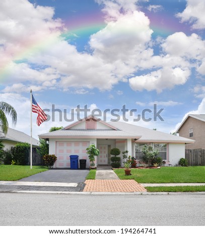 American Flag Rainbow in blue sky with clouds over Suburban Home Landscaped front yard residential neighborhood USA