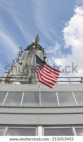 American Flag Pole on building blue sky clouds