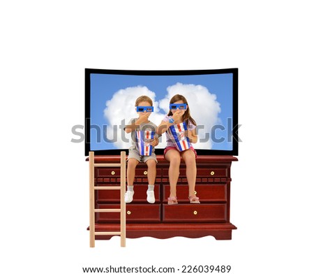 Siblings sitting on wood dresser furniture in front of flat screen TV eating popcorn wearing 3D eyeglasses isolated on white background