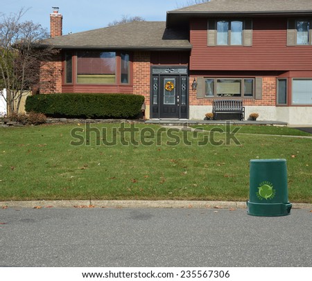 Recycle trash container  on street in front of Suburban high ranch house residential neighborhood USA