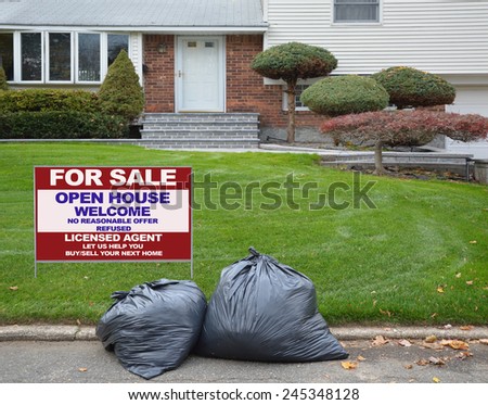 Real Estate for sale open house welcome sign behind black plastic Trash bags curbside suburban home residential neighborhood USA