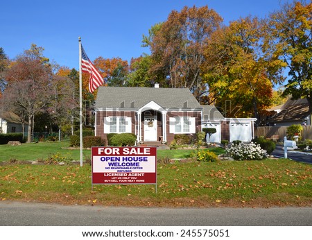 American flag pole real estate for sale open house welcome sign front yard lawn Suburban brown bungalow home autumn day clear blue sky residential neighborhood USA