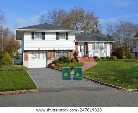 Green recycle, reuse, reduce, trash container Suburban home autumn day residential neighborhood USA