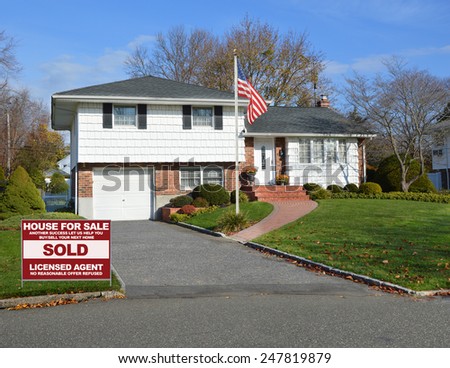 Real estate sold (another success let us help you buy sell your next home) sign Suburban home autumn day residential neighborhood USA