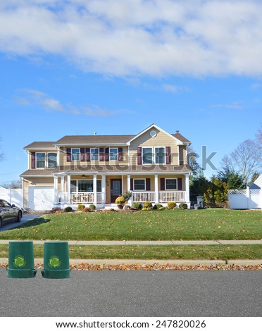 Green recycle, reuse, reduce, trash container Suburban McMansion home autumn day residential neighborhood USA