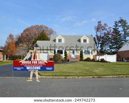 Mannequin wearing red tie Real estate for sale open house welcome sign suburban cape cod home autumn blue sky day residential neighborhood USA