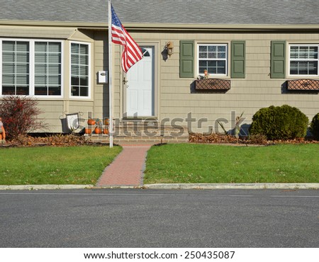 American flag pole closeup view Suburban home landscaped lawn sunny residential neighborhood autumn day USA