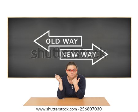 Professional Female Teacher holding chalk in front of blackboard with Old Way New Way arrows pointing in opposite directions isolated on white background