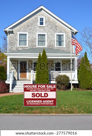 Real estate sold (another success let us help you buy sell your next home) sign Beautiful Gable style  Suburban Home Sunny Autumn clear blue sky day residential neighborhood USA