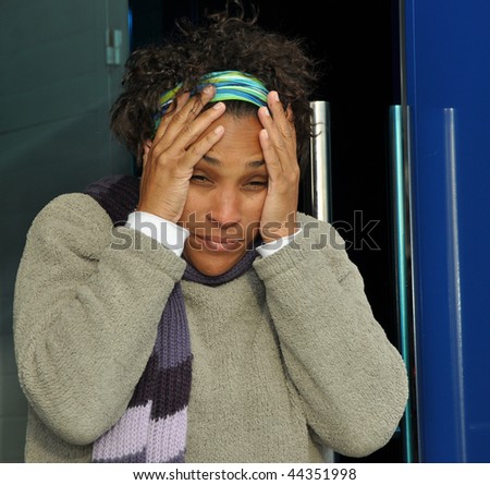 African American woman with her hands on her head looking stressed