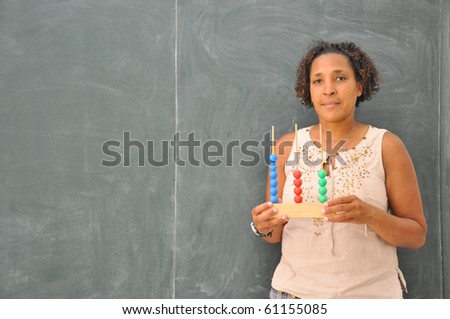 Mature Professional Woman Teacher in Classroom with Elementary School Abacus