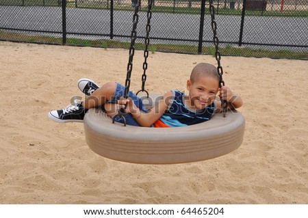 Biracial Little Boy on Playground Tire Swing