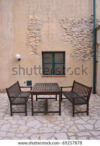 Mediterranean Outdoor Patio Table and Benches with Old Cement Stone Wall and Window in Spain Europe