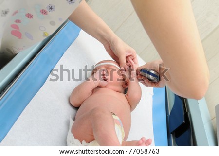 Close Up Newborn Infant Baby on Pediatric Scale Table Getting Head Measured by Nurse in Medical Office