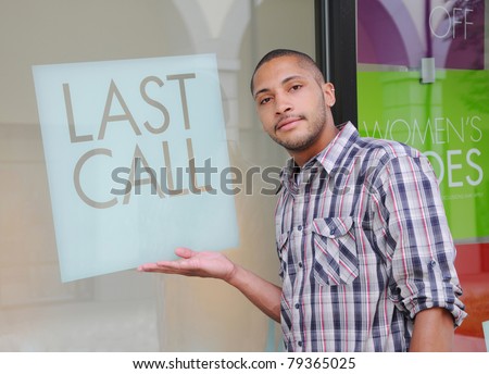 Handsome Young Man wearing plaid shirt next to Window Sign Short Phrase LAST CALL