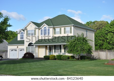 Suburban Two Story Two Car Garage Home Manicured Lawn Landscape Sunny Day