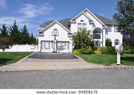 Suburban Luxury Two Story Two Car Garage Home Basketball Hoop Designer Driveway Mailbox Front Yard Sunny Day