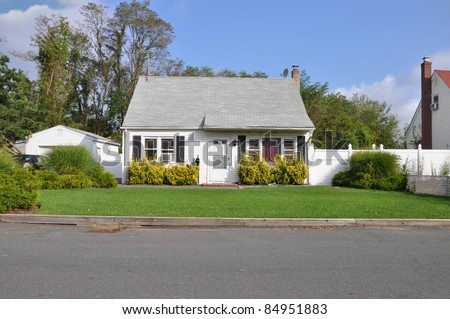 Small Bungalow Cottage Style Suburban Home on Sunny Day in Residential Neighborhood