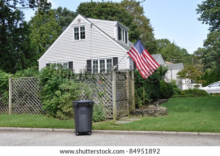 Trash Can Suburban Neighborhood Cape Cod Style Home with American Flag
