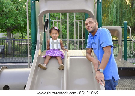 Two Generation Family Father Daughter On Playground Slide