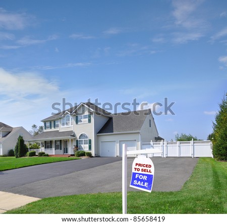 Real Estate For Sale Sign on Front Yard Lawn of Large Luxury Extra Wide Blacktop Driveway Suburban Residential Neighborhood Home on Beautiful Sunny Blue Sky Day