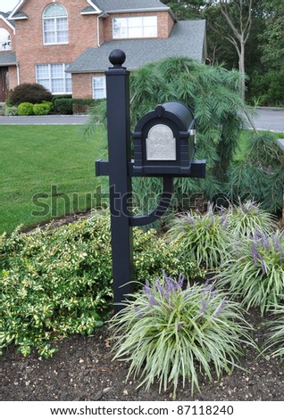 Black Mailbox on Landscaped front yard Plants Brick Home in Background