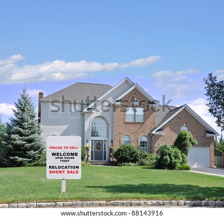 Relocation Short Sale Realtor Sign on Landscaped Front Yard Lawn of Suburban Home in Residential Neighborhood