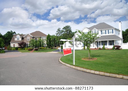 For Sale Sign on Front Lawn of Suburban Culdesac Home in Residential Neighborhood