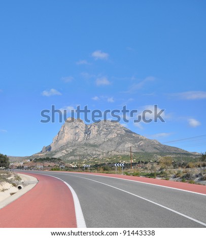 Two Lane Highway leading to Puig Campana (Bell Peak) Mountain in Finestrat a small town in the community of Valencia and the province of costa blanca Alicante Spain Europe on sunny blue sky day