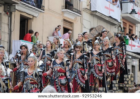 ALCOY, SPAIN - MAY 14: Women dressed in 15th century costumes on float in the largest  Moros y Cristianos parade celebration held annually in the main plaza of Alcoy Spain May 14, 2011.