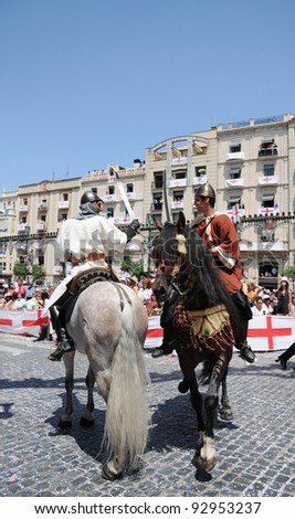 ALCOY, SPAIN - MAY 14: Two men dressed as Christians imitating a 15th century warrior horse battle during  the Moors and Christians celebration parade held annually in Alcoy Spain May 14, 2011.