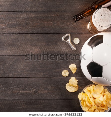 glass of beer. snack and soccer ball with copy space. Wooden background