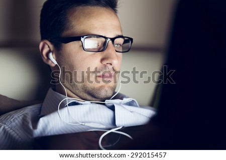 The young handsome guy see a video in his computer at night