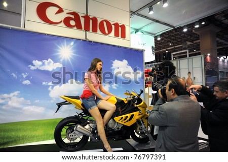 ISTANBUL, TURKEY - APRIL 14: Model and motorbike on April 14,2011 in Photo exhibition show Istanbul, Turkey. 4th Trade fair for photography, digital imaging, albums, printing & technologies equipments