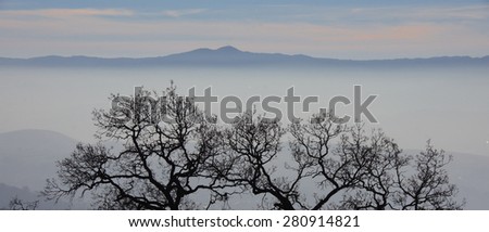 Fog and mist fall over the mountain hilltops of trees in the early morning