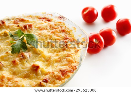 Baked squash with meat, cherry tomatoes and herbs in a glass pot.  Closeup studio shot