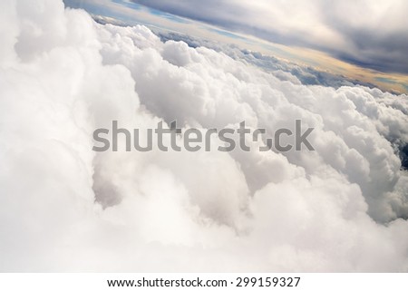 Top view from airplane at the white clouds,  red sunset, thunderstorm
