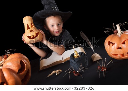 Boy wizard Halloween with pumpkins, magic book, spiders, dead man\'s fingers and candles, Isolated on black background